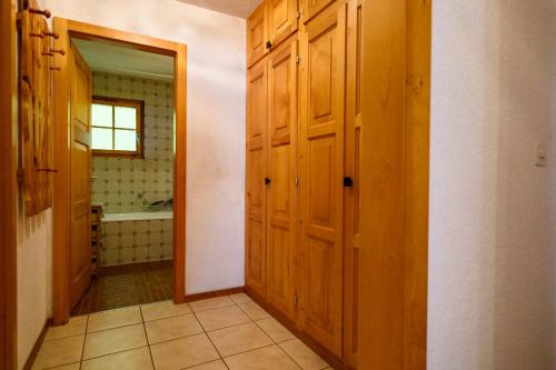 a bathroom with wooden doors and a bath tub at Résidence Dent d'Hérens 18B - au calme à Evolène in Evolène