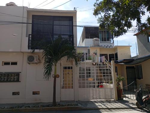 a white house with a palm tree in front of it at Casa Herrera in Santa Cruz Huatulco