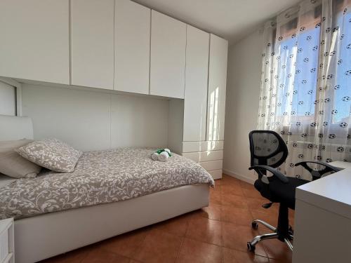 een slaapkamer met een bed, een bureau en een stoel bij Green Luxury House in Casal Palocco