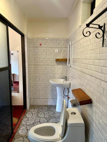 a bathroom with a toilet and a sink at Patamu Restaurants Lodge & Safaris in Karatu