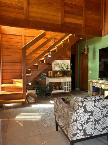 Chalé Vale da Mata - São Roque SP في ساو روكي: غرفة معيشة مع أريكة ودرج خشبي