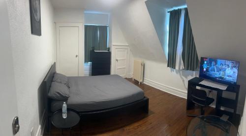 a small room with a bed and a television at Maison Mae Pillars in Mount Vernon