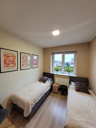 a bedroom with two beds and a window at Malinowa 36 Apartamenty in Chojnice