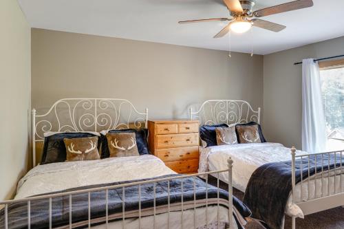 a bedroom with two beds and a ceiling fan at PMC Mountainside Cabin Hit the Trails, Play Pool! in Pine Mountain Club