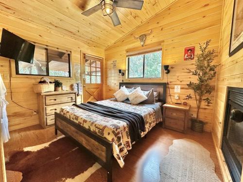 ein Schlafzimmer mit einem Bett in einer Holzhütte in der Unterkunft Western theme! Amazing Spa, Fireplace and Deck! in Overgaard
