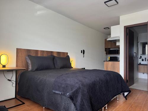 ein Schlafzimmer mit einem großen Bett und eine Küche in der Unterkunft Black Chic Studio in Cochabamba