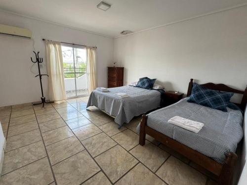 een slaapkamer met 2 bedden en een tegelvloer bij La Soñada in Mercedes
