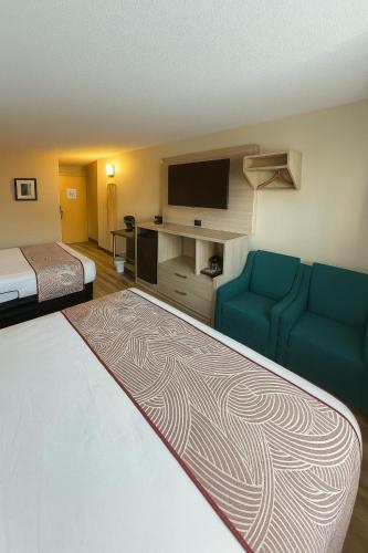 a hotel room with two beds and a flat screen tv at Floral Park Motor Lodge in Floral Park