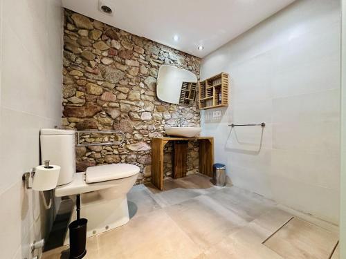 een stenen badkamer met een toilet en een wastafel bij Can Sala CostaBravaSi in Santa Cristina d'Aro