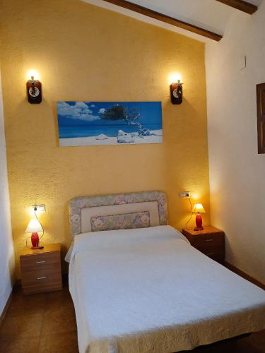 a bedroom with a bed and two lights on the wall at Marítim family resort, Riumar 1 in Riumar
