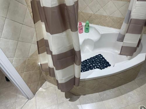 een douche met een douchegordijn in de badkamer bij מנוחה ומרגוע in Tiberias