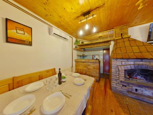 a dining room with a table and a fireplace at Cavljak Retreat, Sarajevo in Barice