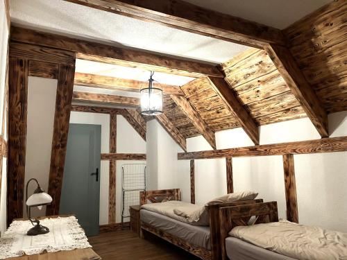 a bedroom with two beds and wooden beams at Leśny Sentyment na Gwizdówce na Kaszubach in Załakowo
