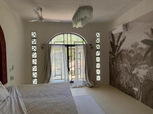 a bedroom with a bed and a large window at Bellerive in Kilifi