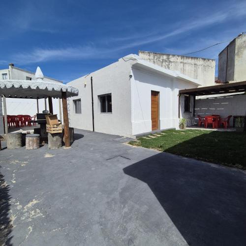 un edificio blanco con patio y mesa en Casa en el centro de Piriapolis a 1 cuadra de la playa, en Piriápolis