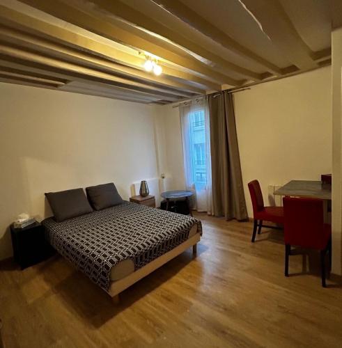 une chambre avec un lit et une table dedans dans l'établissement Montparnasse, à Paris