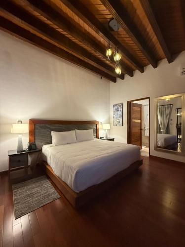 a bedroom with a large bed and a large mirror at Mirtala Hotel Boutique in Guanajuato