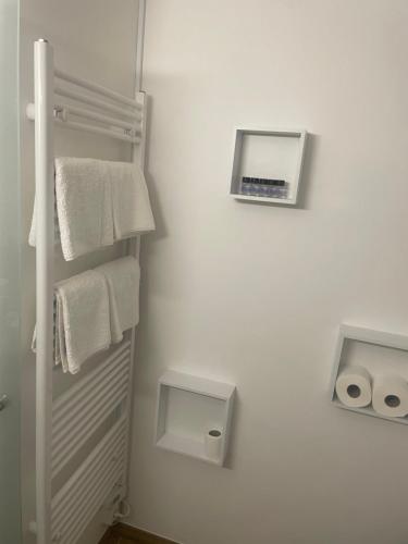 a white bathroom with a towel dispenser on the wall at Sunflower in Kranjska Gora