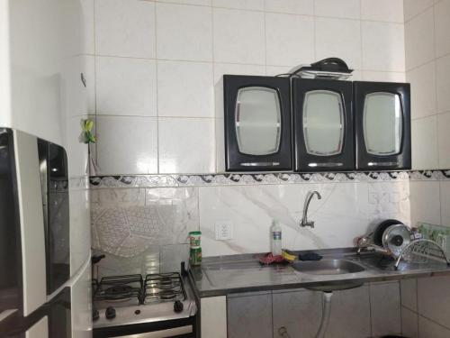 een keuken met een wastafel en twee spiegels aan de muur bij Suítes Privativas - Casa Compartilhada in São Raimundo Nonato