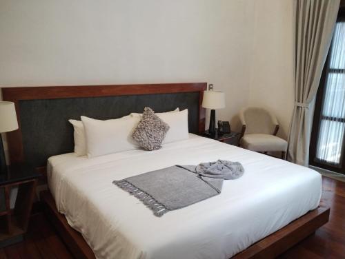 een slaapkamer met een groot bed met witte lakens en kussens bij Mirtala Hotel Boutique in Guanajuato