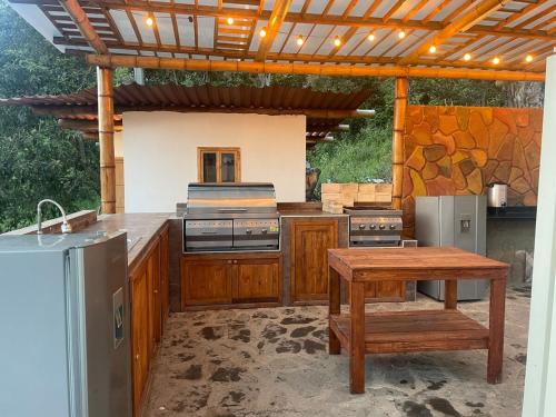 een buitenkeuken met een houten aanrechtblad en een houten tafel bij Cabaña montaña Choachi in Choachí