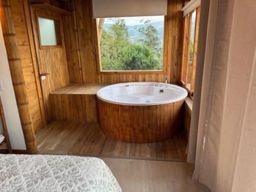 een groot bad in een kamer met een raam bij Cabaña montaña Choachi in Choachí
