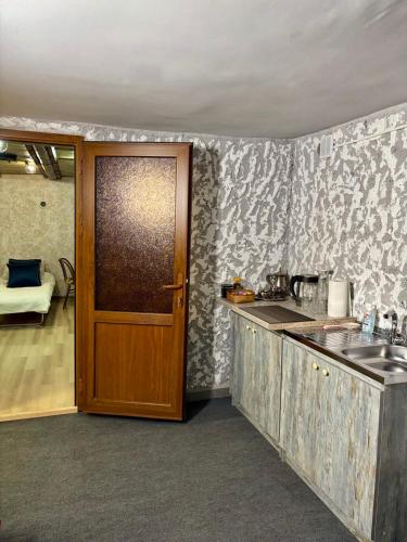 kuchnia z drzwiami prowadzącymi do kuchni ze zlewem w obiekcie Guest House 52 w mieście Goris