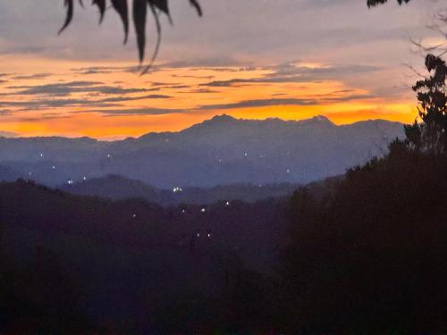 Cabaña Guanara في Vergara: غروب الشمس مع الجبال في الخلفية