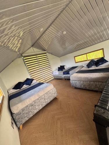 Cabaña Guanara في Vergara: ثلاثة أسرة في غرفة مع سقف