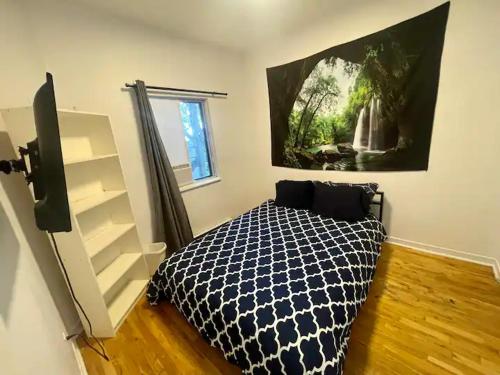 FULL KITCHEN 13min from DTOWN Room B في مونتريال: غرفة نوم بها سرير ولوحة على الحائط