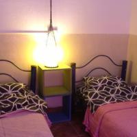 a bedroom with two beds and a lamp on a table at Hospedaje La Rana in Buenos Aires