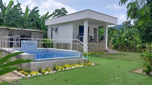 uma casa com piscina no quintal em Paraiso Escondido Guachaca em Guachaca