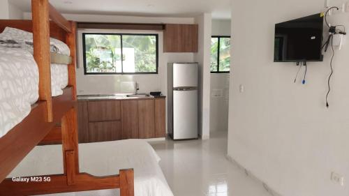 uma cozinha com uma cama e um frigorífico num quarto em Paraiso Escondido Guachaca em Guachaca