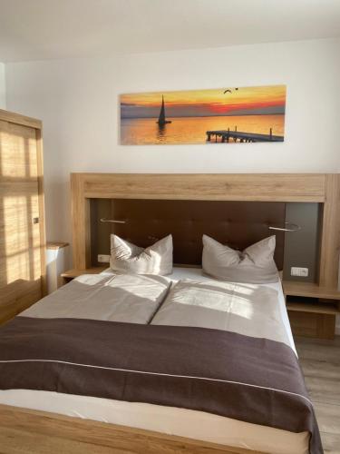 Un dormitorio con una cama grande con un cuadro en la pared. en Pension Zum Alten Fährhaus, en Rostock