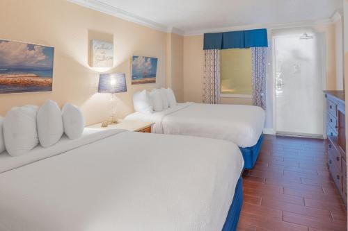 Relaxing Oceanfront Condo - Holiday Pavilion 211 في ميرتل بيتش: غرفة فندق بها سريران ونافذة