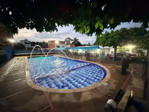 Centro Vacacional Los Pijaos في كارمن دي أبيكالا: مسبح مع نافورة في موقف سيارات ليلاً