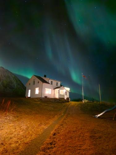 a house on the side of a dirt road under the aurora at This Old House - Check in Breathe out in Strønstad