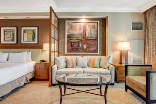 a hotel room with a bed and a couch and a table at The Signature at MGM Grand by Owners Direct in Las Vegas