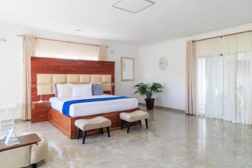 a bedroom with a large bed and two chairs at Comfort B&B in Bulawayo