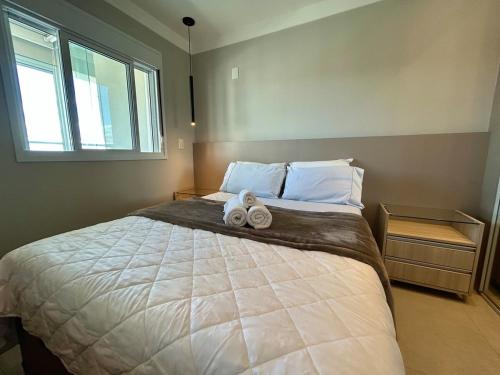 a bedroom with a large bed with two towels on it at Lindo Studio No Coração da Cidade e Prox ao Aeroporto in Guarulhos