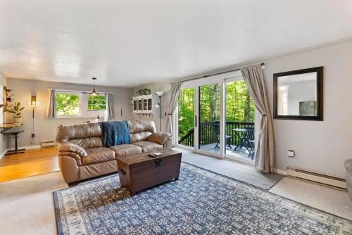 un salon avec un canapé et une table dans l'établissement Little Longbow Lakefront Chalet, à Becket