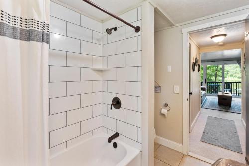 a white bathroom with a tub and a shower at Little Longbow Lakefront Chalet in Becket
