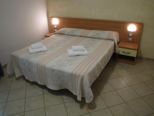 Residence Rosemary في برنزوني سول جاردا: غرفة نوم بها سرير عليه منشفتان