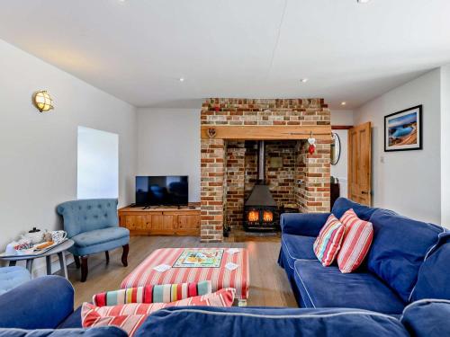 a living room with a blue couch and a fireplace at 4 Bed in Wareham oc-dc176 in West Lulworth
