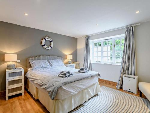 ein Schlafzimmer mit einem großen Bett und einem Fenster in der Unterkunft 4 Bed in Wareham oc-dc176 in West Lulworth