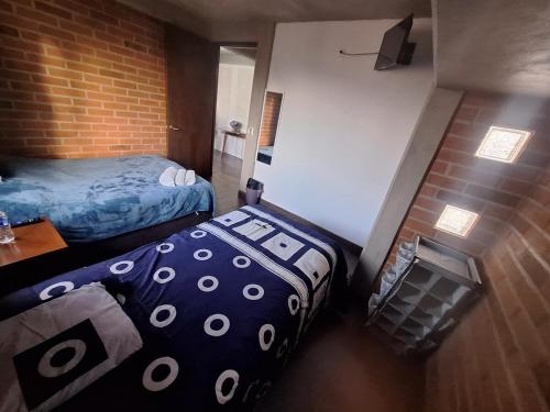 a room with two beds and a brick wall at departamento 2 en condominio in Amecameca de Juárez