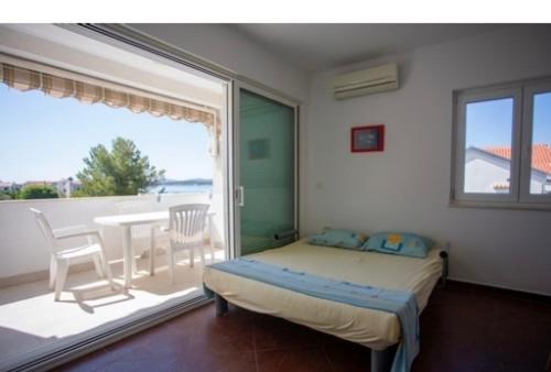 een slaapkamer met een bed, een tafel en een raam bij Lucia&Laura in Turanj