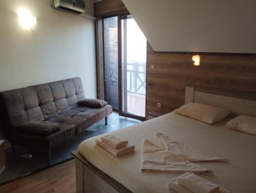 una camera da letto con un letto grande e un divano di Paradise with a sea view a Burgas