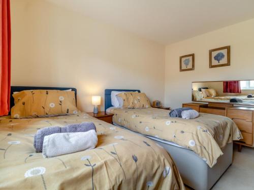 a bedroom with two beds and a mirror at 3 Bed in Brancaster Staithe oc-kt150 in Brancaster