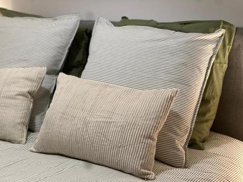 a pile of pillows sitting on a bed at Sand & Chill - Appartement 65R in Rouffach